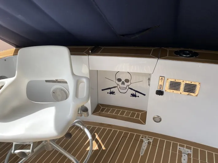 The Jolly Rogers Yacht Photos Pics 1987 Hi-Star Sportfish boat interior with white captain's chair and skull decal.