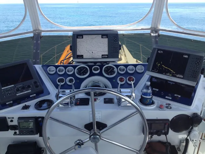 The Jolly Rogers Yacht Photos Pics 1987 Hi-Star Sportfish boat helm with navigation equipment and ocean view.