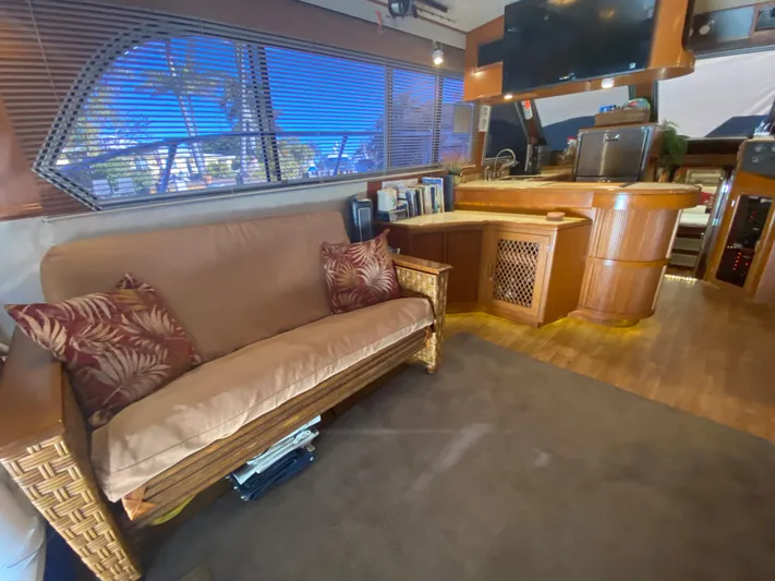 The Jolly Rogers Yacht Photos Pics 1987 Hi-Star Sportfish yacht interior with sofa, wooden cabinetry, and large windows.