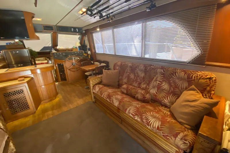 The Jolly Rogers Yacht Photos Pics Interior of 1987 Hi-Star Sportfish yacht with tropical-themed sofa and wooden helm station.