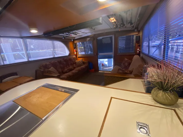 The Jolly Rogers Yacht Photos Pics 1987 Hi-Star Sportfish boat interior with cozy seating and large windows.