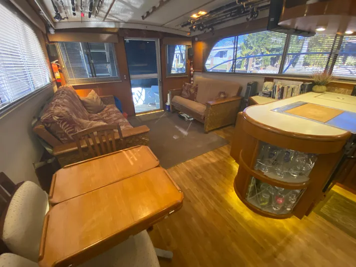 The Jolly Rogers Yacht Photos Pics Interior of a 1987 Hi-Star Sportfish boat with cozy seating and wooden furnishings.