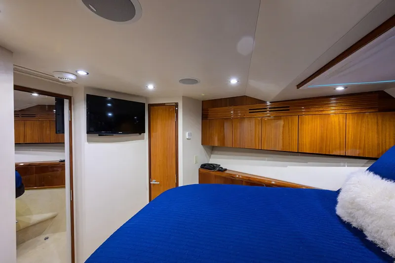 Sapphire Yacht Photos Pics Luxurious 2009 Hatteras Enclosed Bridge yacht interior with wood cabinetry and blue bedding.