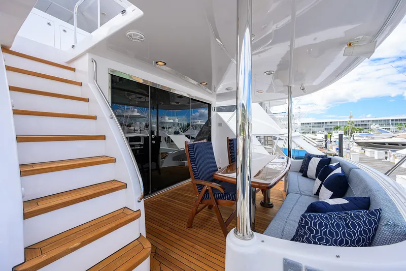 Sapphire Yacht Photos Pics Luxurious 2009 Hatteras Enclosed Bridge yacht deck with seating, table, and staircase.