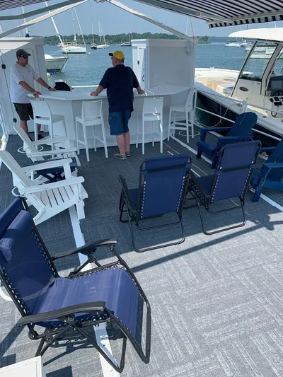  Yacht Photos Pics Custom MKI Pontoon Boat 2022 with seating, bar area, and canopy on a sunny day.