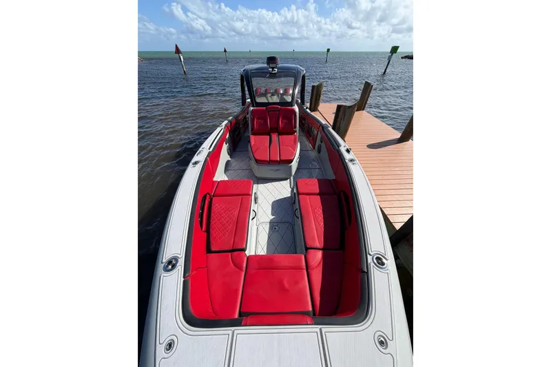 Yacht Photos Pics 2020 Deep Impact 399 Sport boat with red seating, docked by the water.