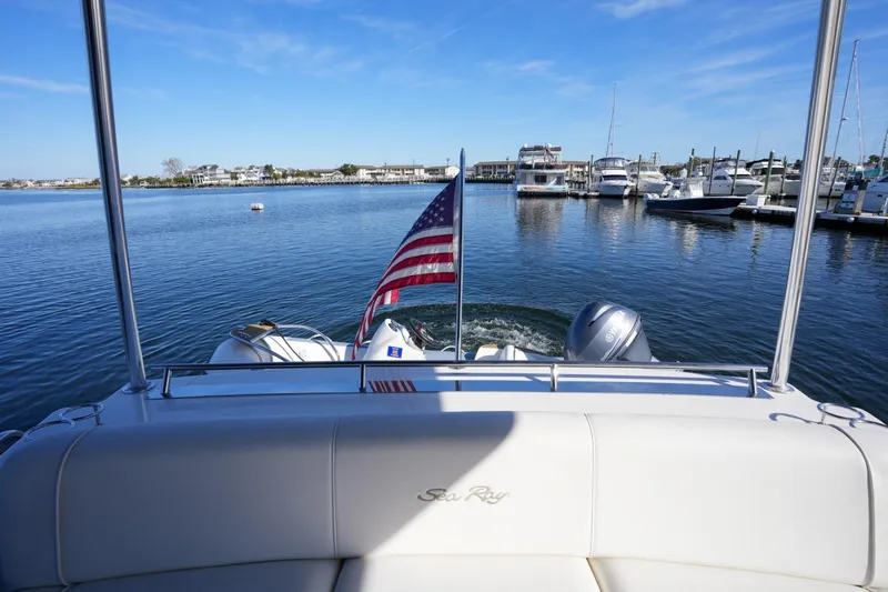 Victoria Yacht Photos Pics 2013 Sea Ray 610 Sundancer yacht with American flag, docked in a marina.