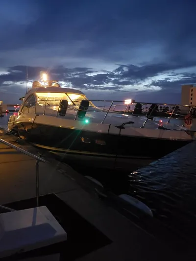 Victoria Yacht Photos Pics 2013 Sea Ray 610 Sundancer yacht docked at sunset, illuminated against a twilight sky.