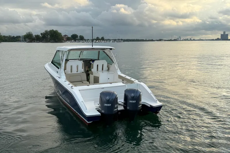 On Pointe Yacht Photos Pics 2016 Pursuit DC 325 Dual Console boat on calm water under cloudy sky.