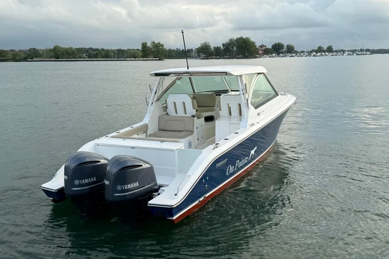 On Pointe Yacht Photos Pics 2016 Pursuit DC 325 Dual Console boat with twin Yamaha engines on a calm lake.