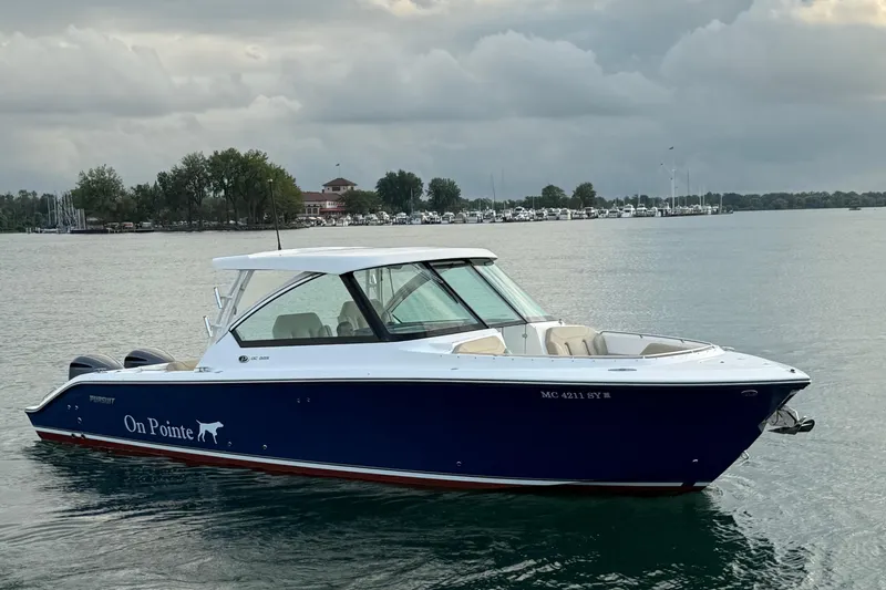 On Pointe Yacht Photos Pics 2016 Pursuit DC 325 Dual Console boat on calm water, cloudy sky background.