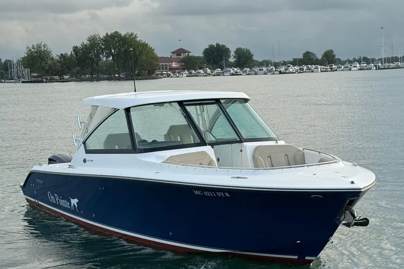 On Pointe Yacht Photos Pics 2016 Pursuit DC 325 Dual Console boat on calm water near marina.