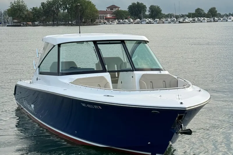 On Pointe Yacht Photos Pics 2016 Pursuit DC 325 Dual Console boat on calm water near marina.