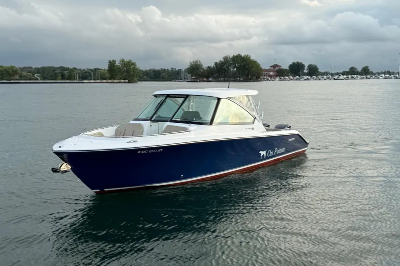 On Pointe Yacht Photos Pics 2016 Pursuit DC 325 Dual Console boat on calm water, overcast sky.