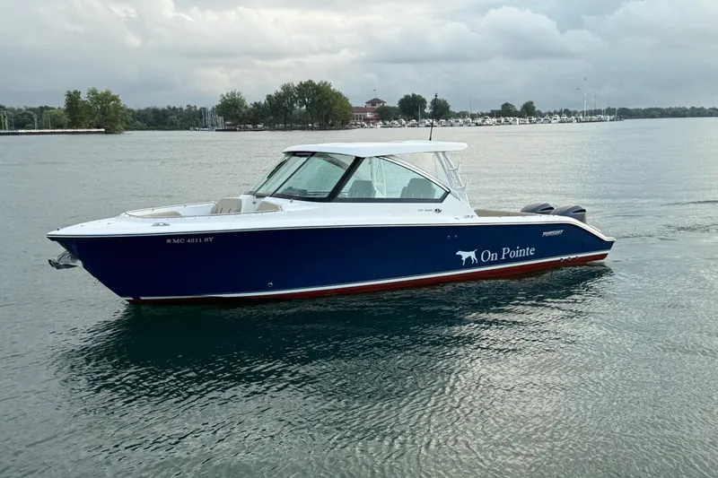 On Pointe Yacht Photos Pics 2016 Pursuit DC 325 Dual Console boat on calm water, overcast sky.