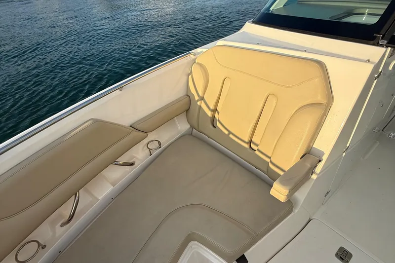 On Pointe Yacht Photos Pics 2016 Pursuit DC 325 Dual Console boat interior with beige seating by the water.