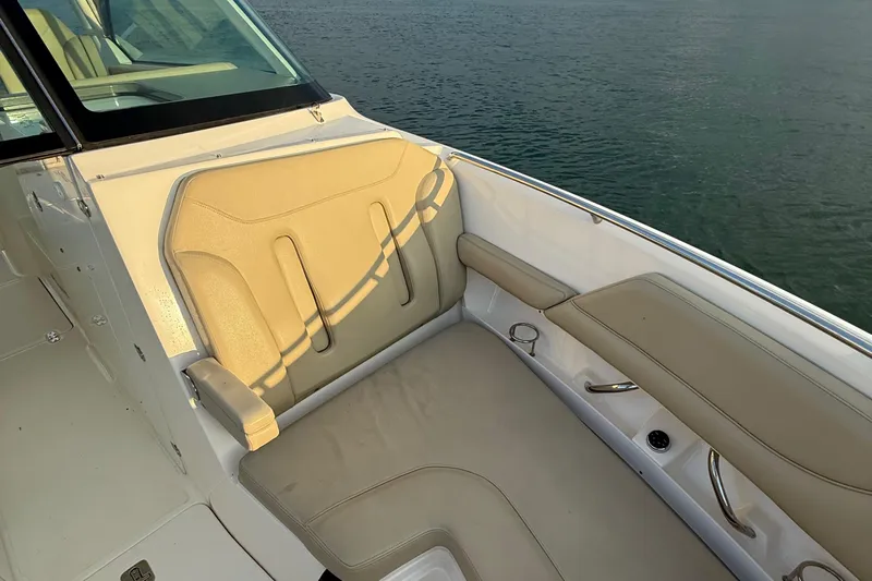 On Pointe Yacht Photos Pics 2016 Pursuit DC 325 Dual Console boat interior with beige seating, overlooking water.