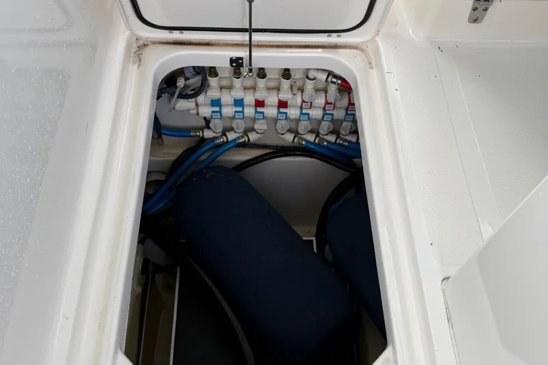 On Pointe Yacht Photos Pics 2016 Pursuit DC 325 Dual Console boat compartment with visible plumbing and hoses.