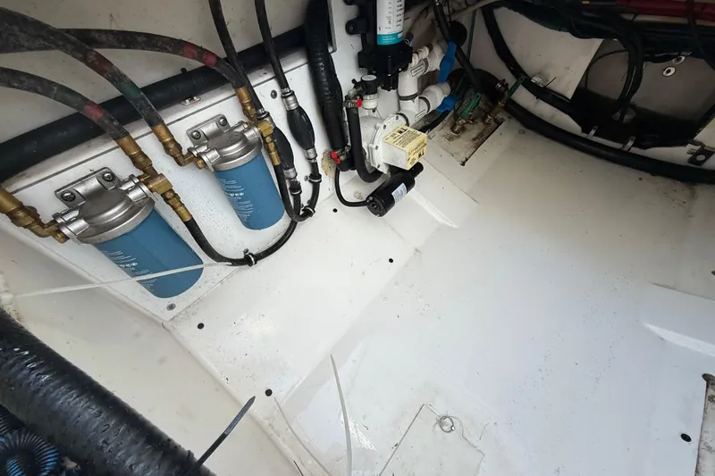 On Pointe Yacht Photos Pics Engine compartment of a 2016 Pursuit DC 325 Dual Console boat, showing filters and hoses.
