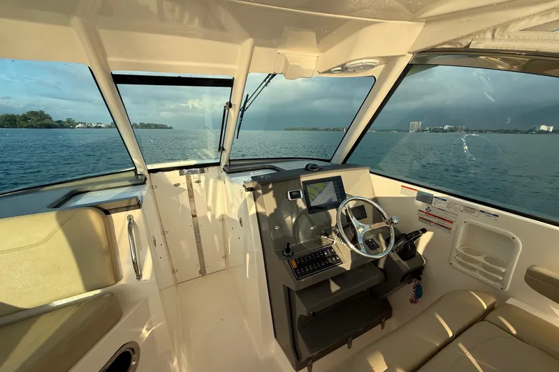 On Pointe Yacht Photos Pics 2016 Pursuit DC 325 Dual Console boat interior with steering wheel and navigation system.