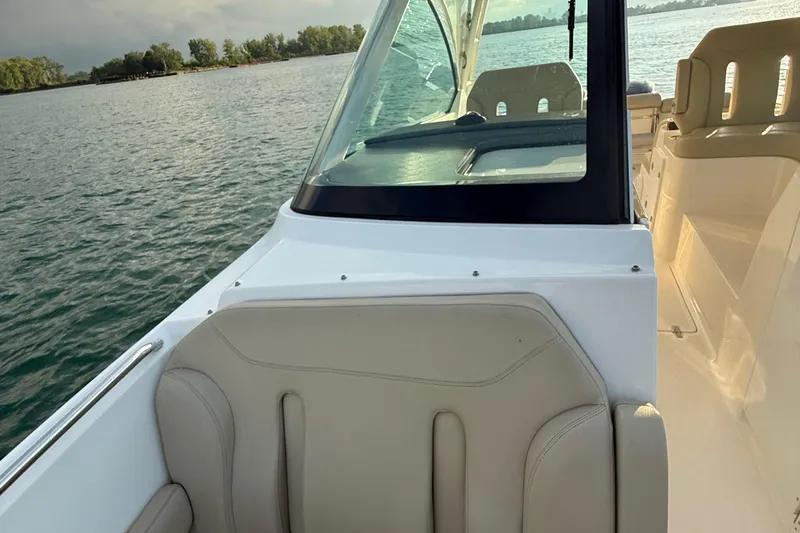 On Pointe Yacht Photos Pics 2016 Pursuit DC 325 Dual Console boat interior with seating, on calm water.