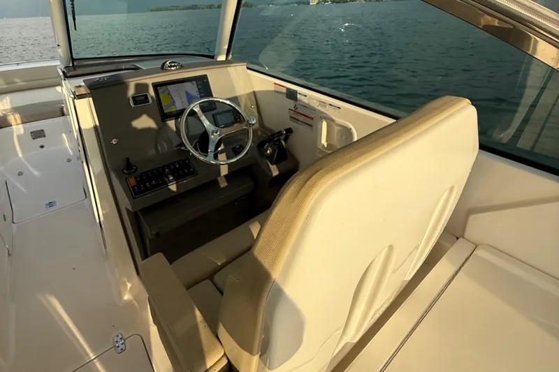 On Pointe Yacht Photos Pics 2016 Pursuit DC 325 Dual Console boat interior with steering wheel and navigation display.