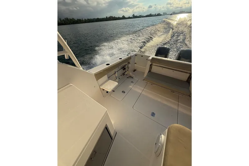 On Pointe Yacht Photos Pics 2016 Pursuit DC 325 Dual Console boat cruising on open water at sunset.