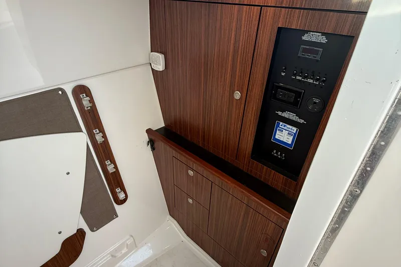 On Pointe Yacht Photos Pics 2016 Pursuit DC 325 Dual Console interior with wood paneling and control panel.