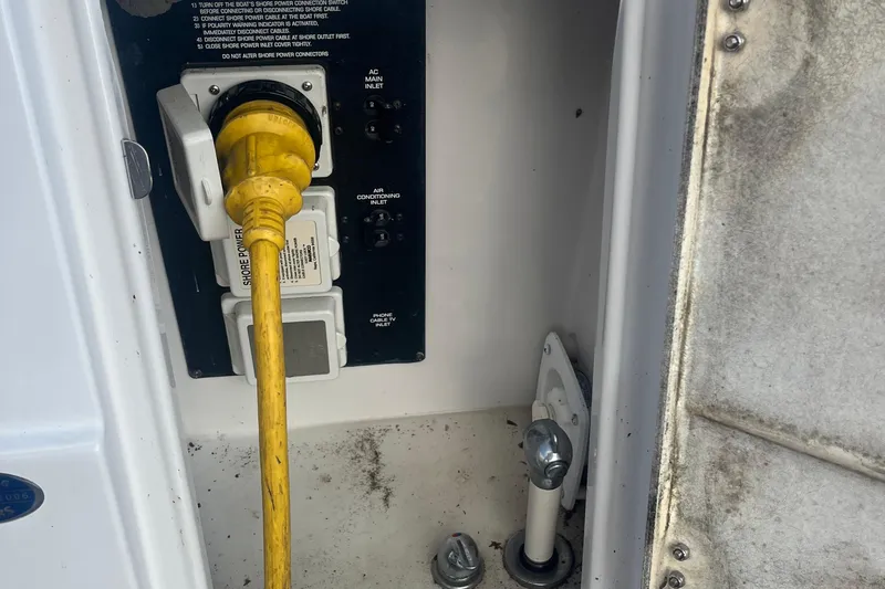 On Pointe Yacht Photos Pics 2016 Pursuit DC 325 Dual Console shore power connection with yellow cable and control panel.