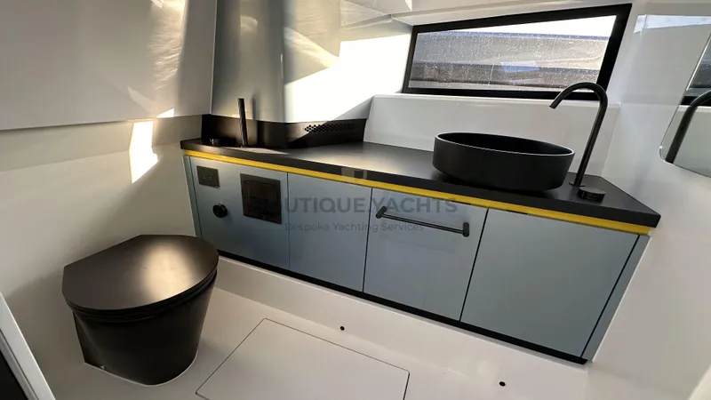 Hull #5 Yacht Photos Pics Modern yacht bathroom with sleek fixtures, black countertop, and round basin. Maori 46ft, 2024 model.
