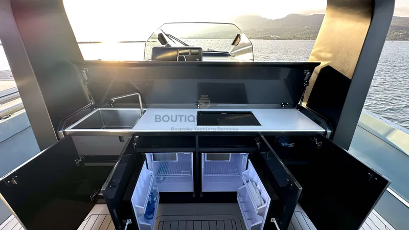 Hull #5 Yacht Photos Pics Modern 2024 Maori 46ft yacht kitchen with sink, stove, and open storage compartments at sunset.