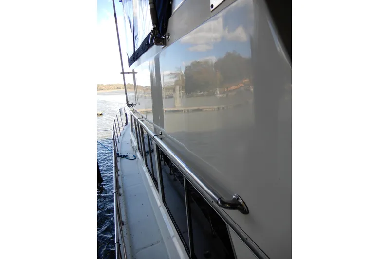  Yacht Photos Pics 1989 Jefferson 46 Sundeck yacht side view with railing, docked by calm waters.