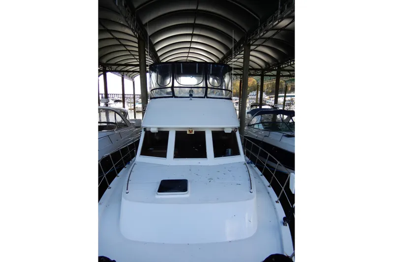  Yacht Photos Pics 1989 Jefferson 46 Sundeck yacht docked under covered marina.