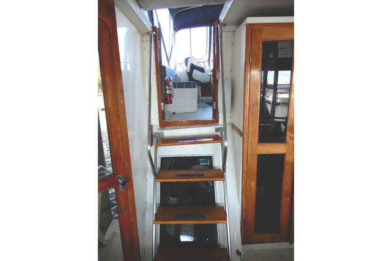  Yacht Photos Pics Interior stairs of 1989 Jefferson 46 Sundeck yacht with wooden accents.