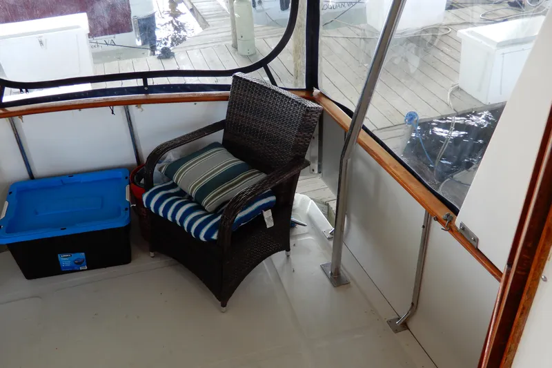  Yacht Photos Pics 1989 Jefferson 46 Sundeck interior with wicker chair and storage box.