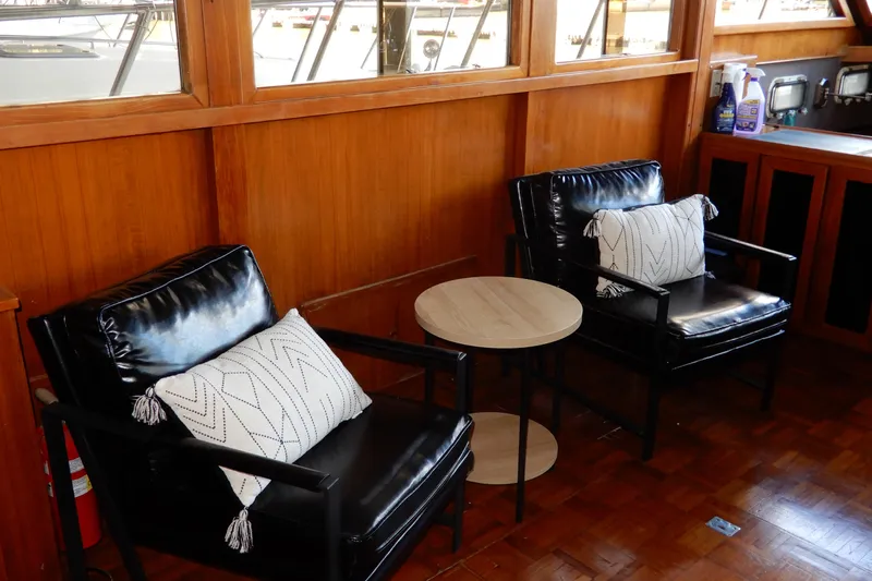  Yacht Photos Pics Interior of 1989 Jefferson 46 Sundeck with black chairs and wooden table.