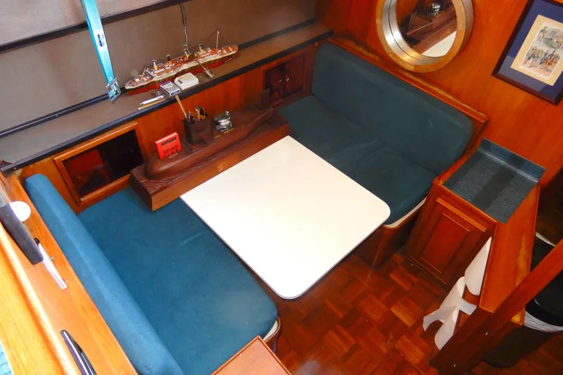  Yacht Photos Pics 1989 Jefferson 46 Sundeck interior with blue seating, white table, and wooden accents.