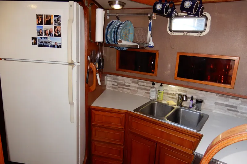  Yacht Photos Pics 1989 Jefferson 46 Sundeck kitchen with fridge, sink, and wooden cabinets.