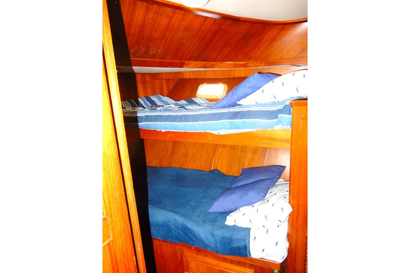  Yacht Photos Pics 1989 Jefferson 46 Sundeck interior with wooden bunk beds and blue bedding.