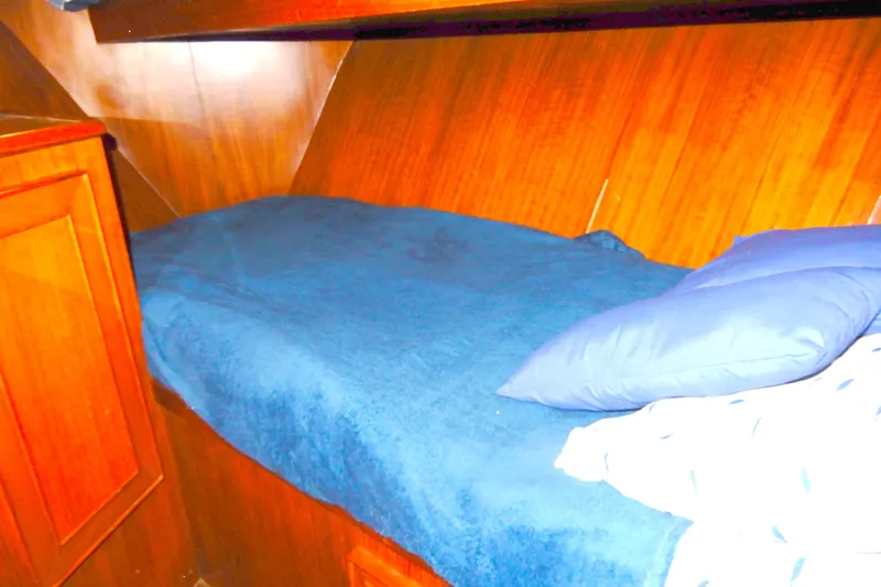  Yacht Photos Pics 1989 Jefferson 46 Sundeck cabin interior with wooden paneling and blue bedding.