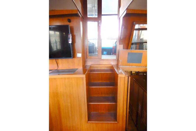  Yacht Photos Pics Interior of 1989 Jefferson 46 Sundeck yacht with wooden stairs and mounted TV.