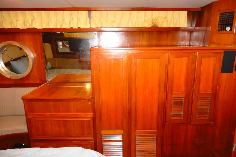  Yacht Photos Pics 1989 Jefferson 46 Sundeck interior with wooden cabinetry and porthole window.