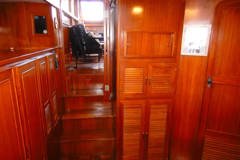  Yacht Photos Pics 1989 Jefferson 46 Sundeck interior with wooden cabinetry and stairs leading to seating area.