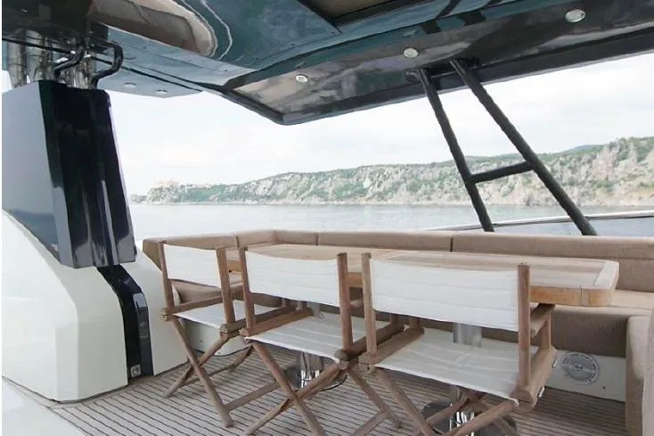 Tyche Yacht Photos Pics 2019 Monte Carlo Yachts MCY 76 deck with seating, overlooking scenic coastal view.