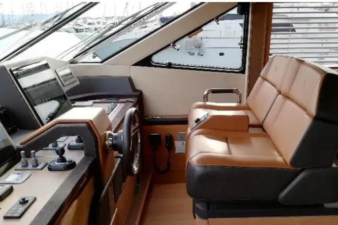 Tyche Yacht Photos Pics Luxurious helm of 2019 Monte Carlo Yachts MCY 76 with leather seating and modern controls.