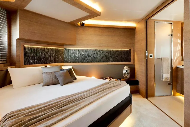 Tyche Yacht Photos Pics Luxurious bedroom interior of 2019 Monte Carlo Yachts MCY 76, featuring elegant wood finishes.