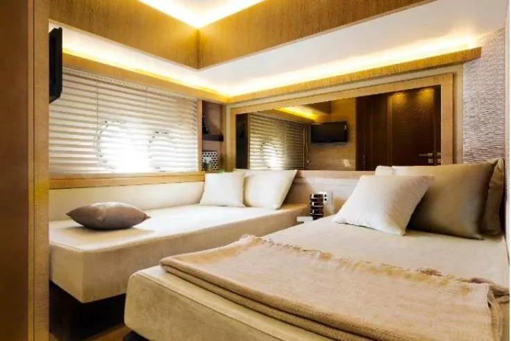 Tyche Yacht Photos Pics Luxurious interior of 2019 Monte Carlo Yachts MCY 76 with elegant bedding and ambient lighting.