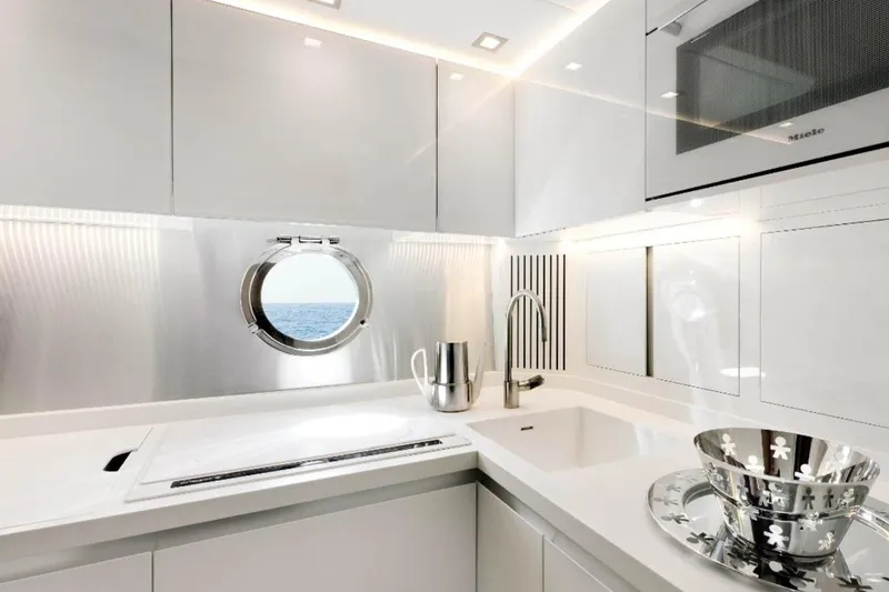 Tyche Yacht Photos Pics Luxurious kitchen interior of 2019 Monte Carlo Yachts MCY 76 with ocean view porthole.