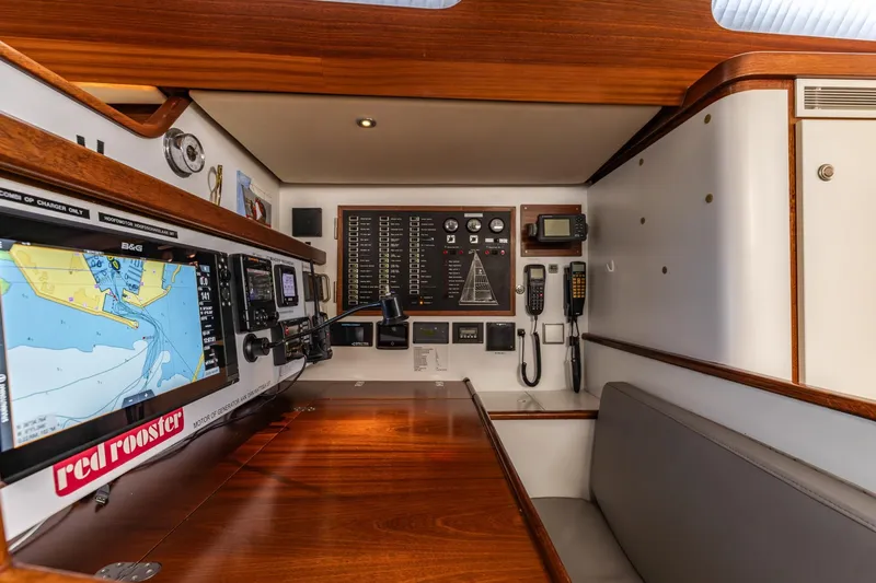 Red Rooster Yacht Photos Pics Navigation station of 2008 Van De Stadt Stadtship 70 yacht with control panels and seating.
