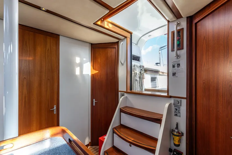 Red Rooster Yacht Photos Pics Interior of 2008 Van De Stadt Stadtship 70 yacht with wooden doors and staircase.